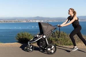 women jogs with kid, When Can a Baby Sit in a Stroller?